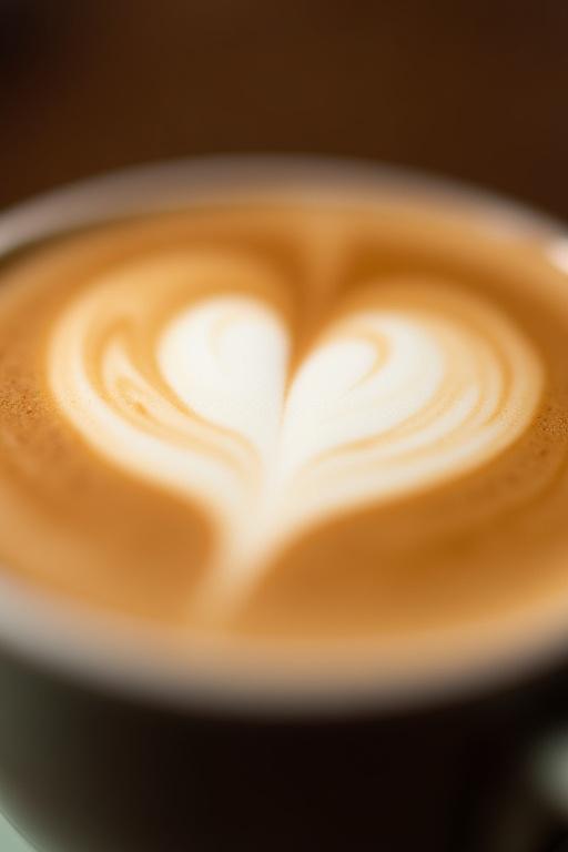 Nærbilde av en latte med hjerteformet kunst i skummet.